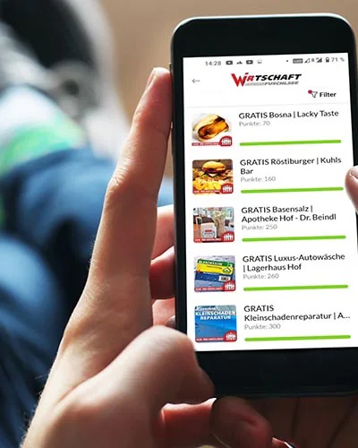 Hand hält ein Smartphone mit einer App-Liste regionaler Angebote - Tourdata-Schnittstelle