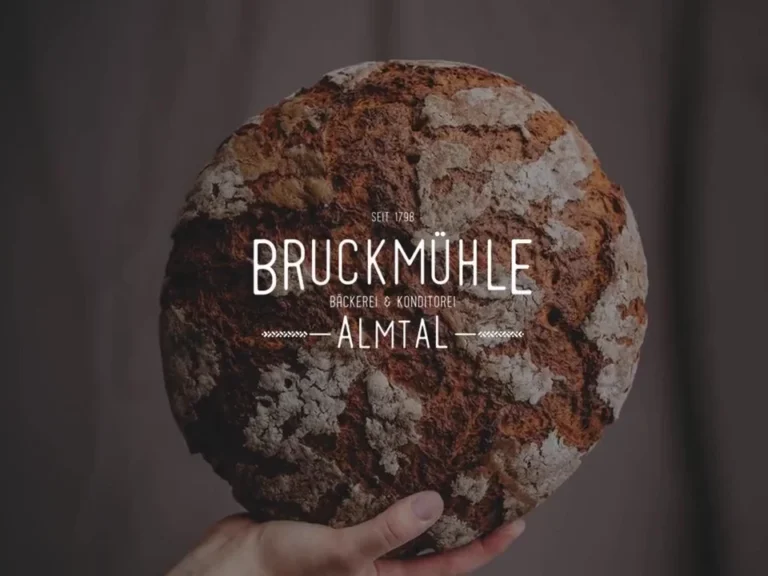 Bäckerei Bruckmühle Almtal - Logo über rustikalem Krustenbrot